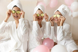 three women in robes with cucumbers on their eyes